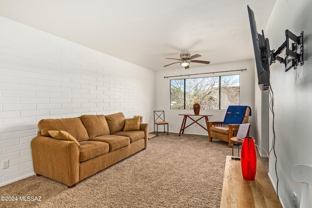 living room with brick wall, ceiling fan, and carpet floors