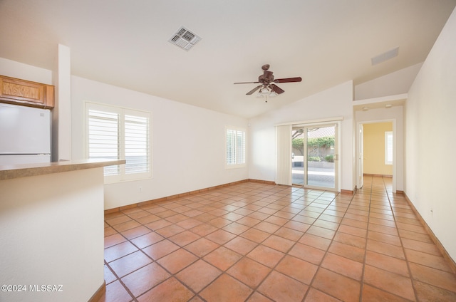 tiled empty room with lofted ceiling and ceiling fan