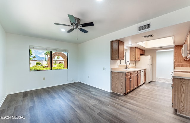 kitchen featuring hardwood / wood-style flooring, ceiling fan, white appliances, and sink