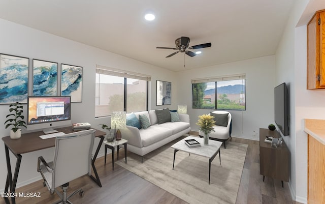 living room featuring light hardwood / wood-style flooring, a wealth of natural light, and ceiling fan