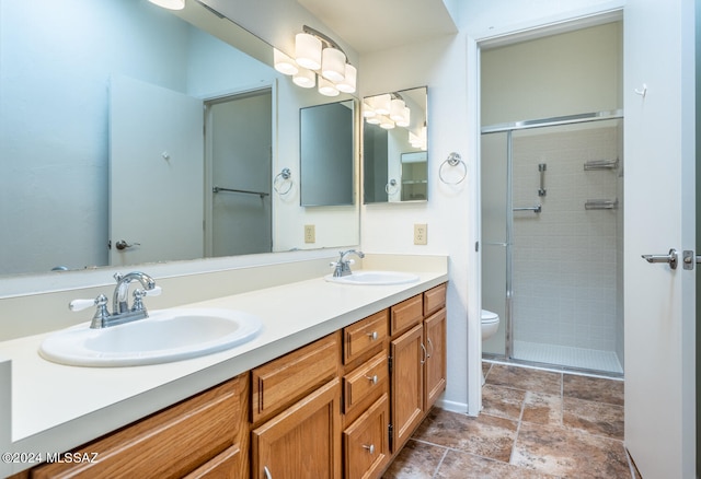 bathroom with vanity, a shower with shower door, and toilet