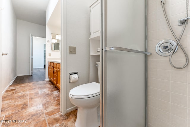 bathroom featuring vanity, toilet, and a shower with door