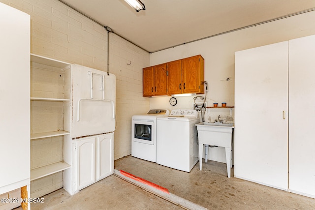 clothes washing area featuring cabinets and washing machine and dryer