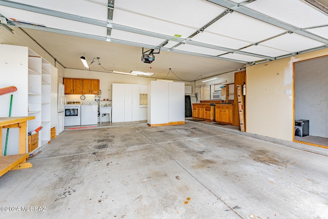 garage with a garage door opener, sink, and washing machine and clothes dryer