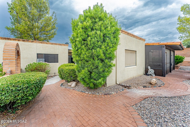 view of home's exterior with a patio and a sunroom