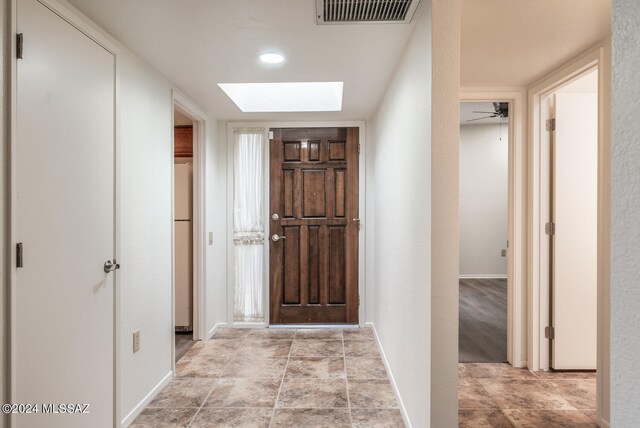 hall featuring a skylight and light hardwood / wood-style floors