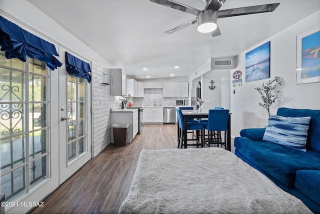 living room featuring dark wood-type flooring, ceiling fan, and sink