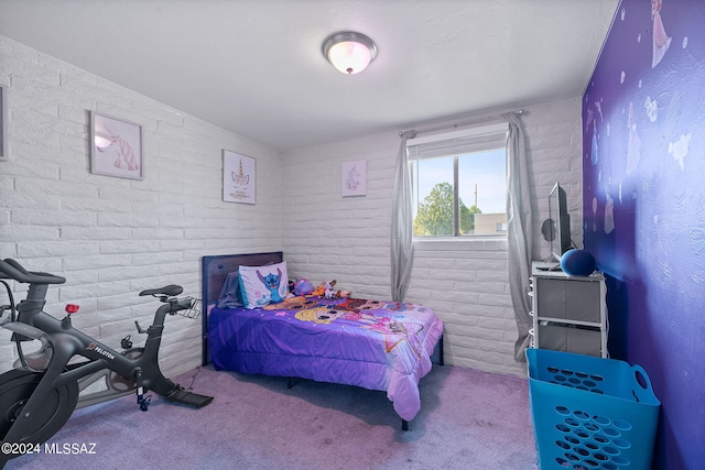 bedroom featuring brick wall and light carpet