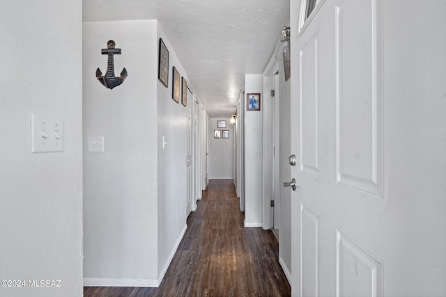 corridor featuring a textured ceiling and dark hardwood / wood-style floors