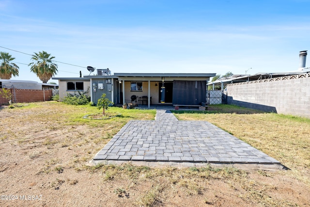 rear view of property with a yard and a patio area