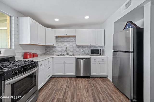 kitchen featuring stainless steel appliances, sink, dark wood-type flooring, vaulted ceiling, and white cabinets