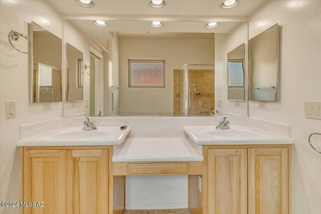 bathroom featuring tiled shower and vanity