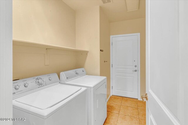 laundry area featuring light tile patterned flooring and washing machine and dryer