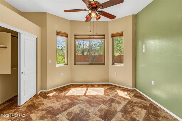 unfurnished bedroom with multiple windows and ceiling fan