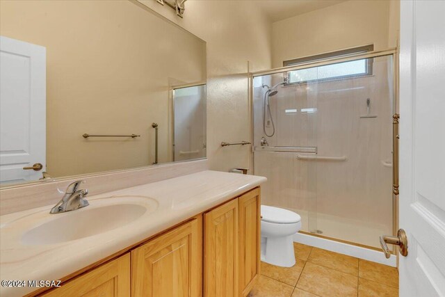 bathroom with vanity, toilet, an enclosed shower, and tile patterned floors