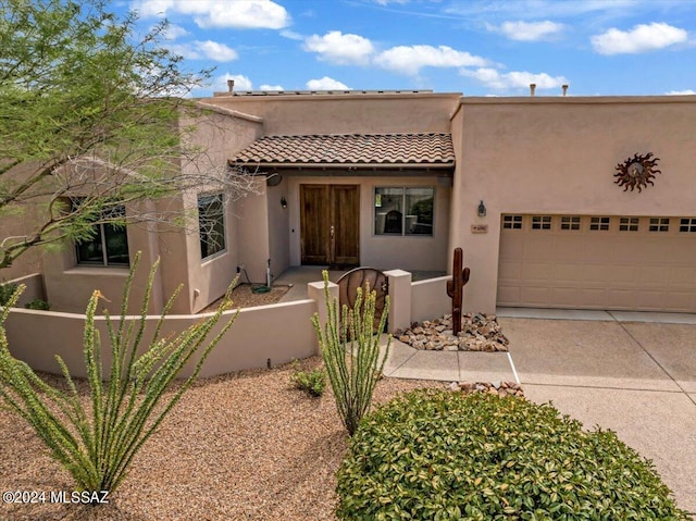 pueblo-style house featuring a garage