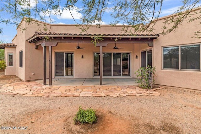 back of property with ceiling fan and a patio area