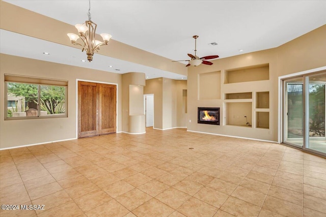 unfurnished living room featuring ceiling fan with notable chandelier and built in features