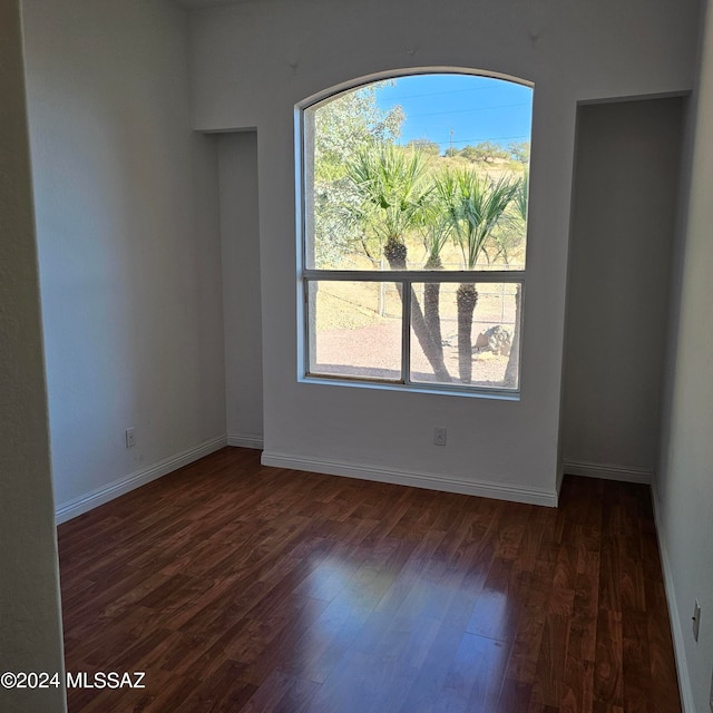 spare room with dark hardwood / wood-style flooring