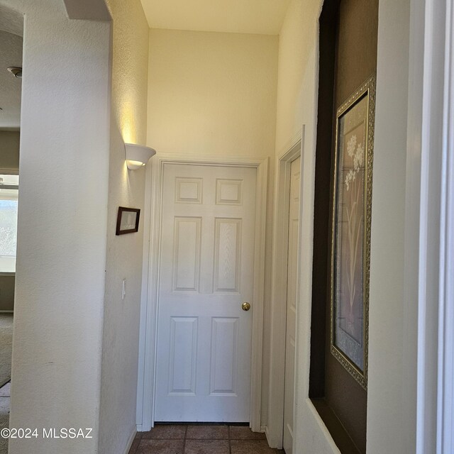 hall with tile patterned floors