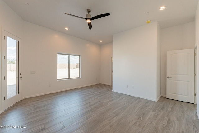 empty room with ceiling fan and light hardwood / wood-style flooring