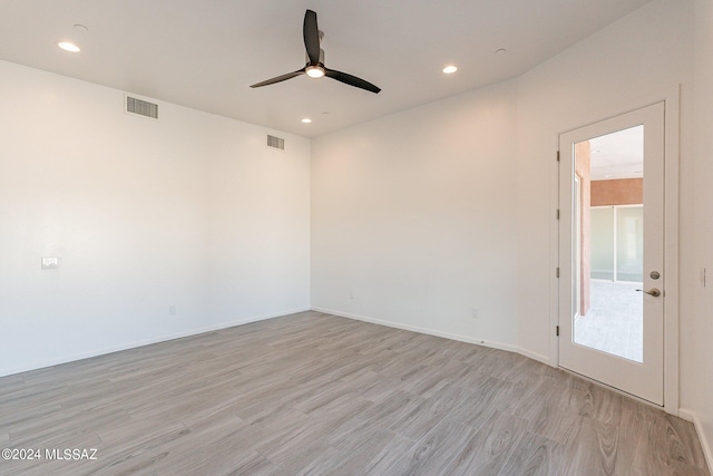 spare room with light wood-type flooring and ceiling fan