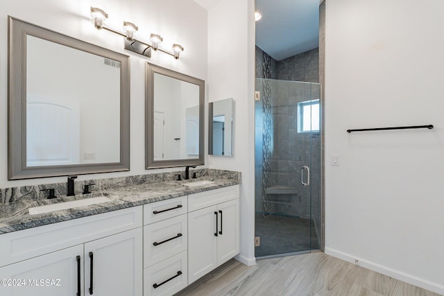 bathroom with vanity, wood-type flooring, and walk in shower