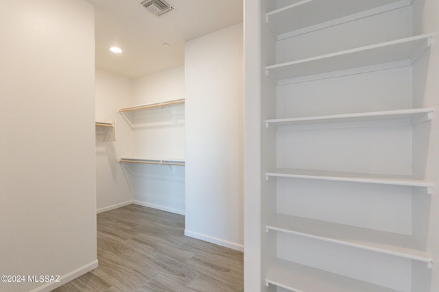 spacious closet featuring hardwood / wood-style floors