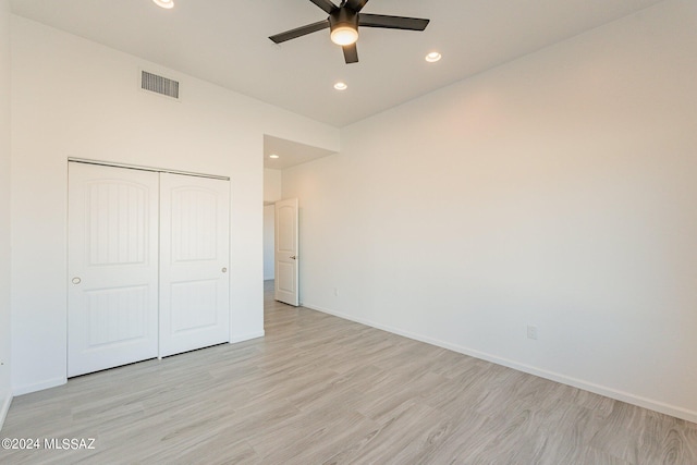 unfurnished bedroom featuring light hardwood / wood-style floors, ceiling fan, and a closet