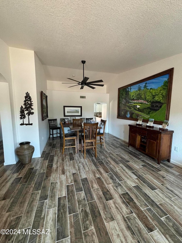 bedroom with ceiling fan, dark hardwood / wood-style floors, and a textured ceiling