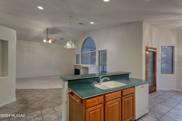 kitchen with vaulted ceiling, dishwasher, ceiling fan, a kitchen island with sink, and sink