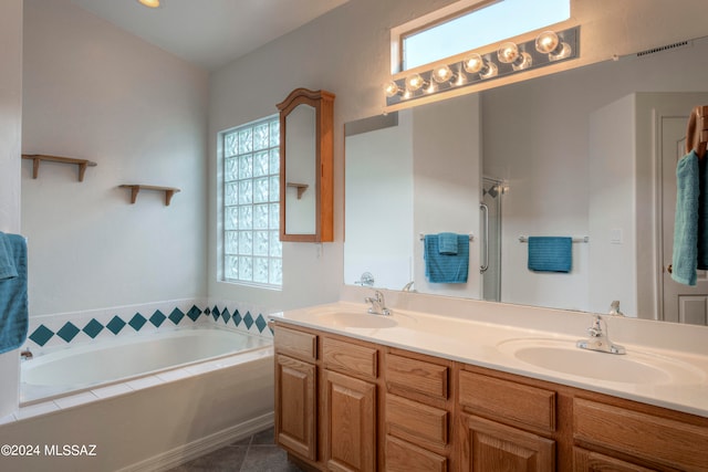 bathroom featuring vanity, tile patterned floors, tiled bath, and a healthy amount of sunlight