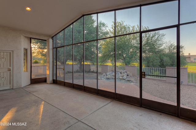 unfurnished sunroom featuring vaulted ceiling