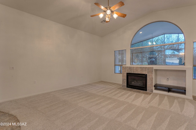 unfurnished living room featuring light carpet, vaulted ceiling, ceiling fan, and a tile fireplace