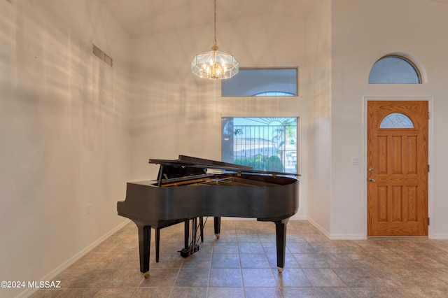 miscellaneous room featuring high vaulted ceiling and a chandelier