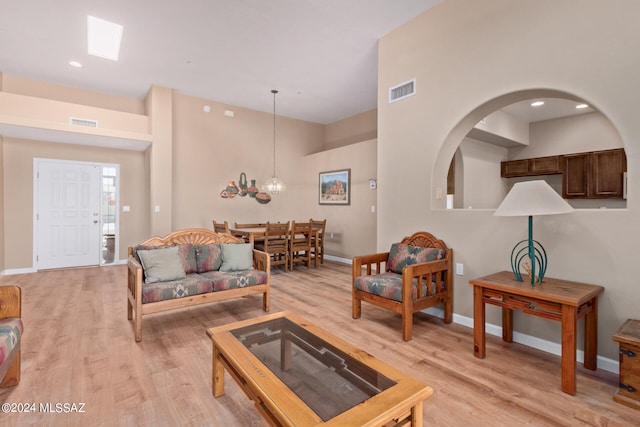 living room featuring light hardwood / wood-style flooring and an inviting chandelier