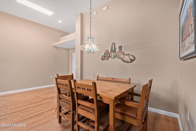 dining area with wood-type flooring and a chandelier