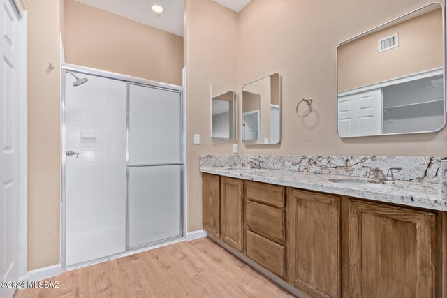 2521 S Pecan Valley Pl, Green Valley, AZ 85614 - bathroom with a stall shower, wood finished floors, double vanity, and baseboards