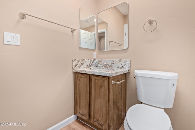 bathroom with vanity, toilet, and hardwood / wood-style floors