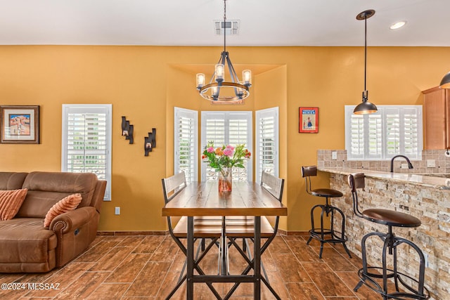 dining room with a chandelier, baseboards, and visible vents