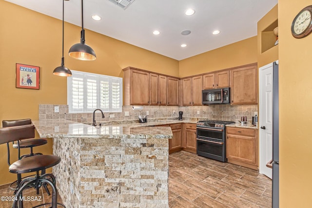 kitchen with pendant lighting, a peninsula, light stone countertops, tasteful backsplash, and range with two ovens