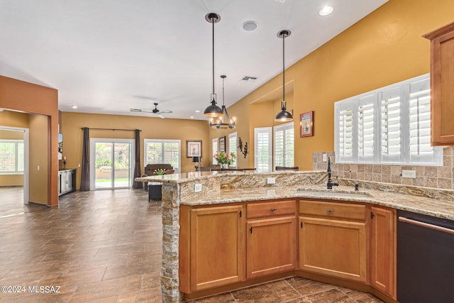 kitchen featuring a healthy amount of sunlight, a peninsula, open floor plan, and dishwasher