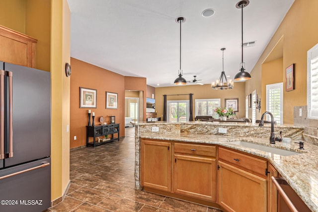 kitchen featuring stainless steel appliances, light stone countertops, visible vents, and a sink