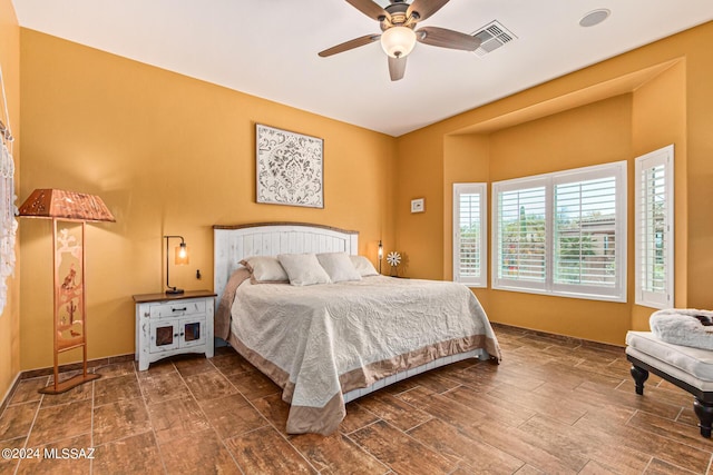 bedroom with visible vents, baseboards, ceiling fan, and wood finished floors