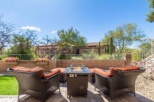 view of patio / terrace with fence and an outdoor living space with a fire pit