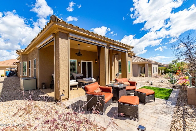 back of property with an outdoor living space, stucco siding, a tiled roof, and a patio