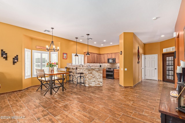 kitchen featuring visible vents, stainless steel microwave, a chandelier, and range with two ovens