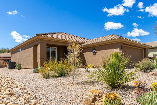 view of front of property with a garage and central AC unit