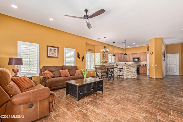 living room featuring ceiling fan with notable chandelier, recessed lighting, and visible vents