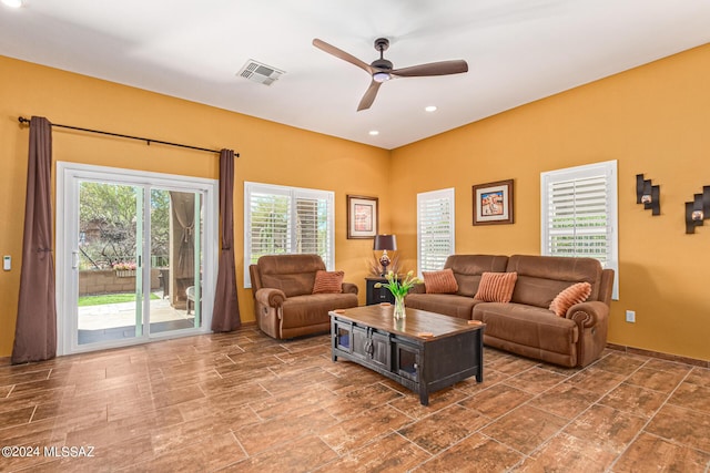 living room featuring ceiling fan with notable chandelier